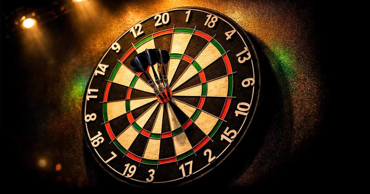 Dartbord verlicht in een sfeervolle arena met publiek op de achtergrond